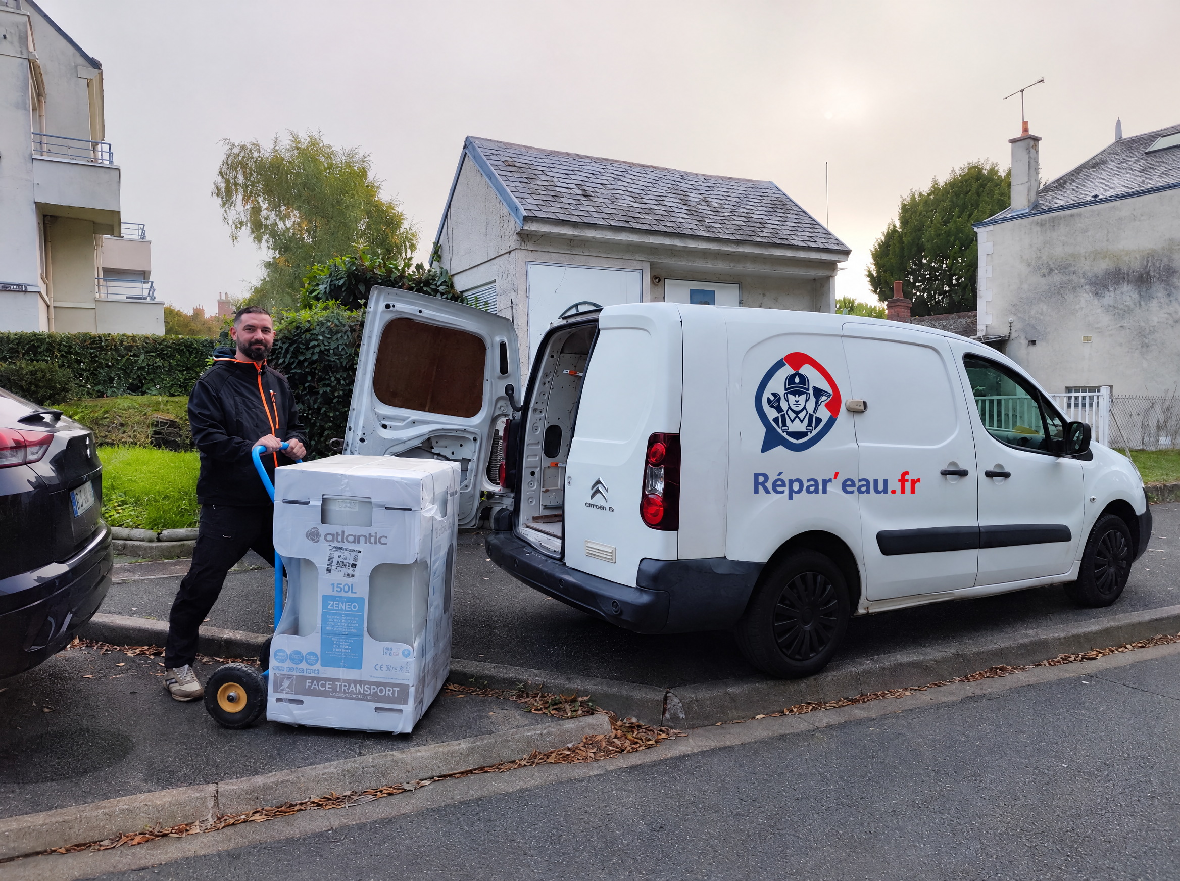 L'artisan Répar'eau devant le camion, un chauffe-eau Atlantic sur le diable